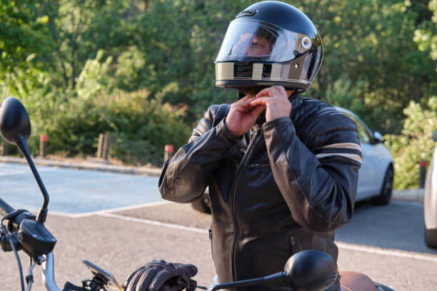 man adjusting his motorcycle helmet